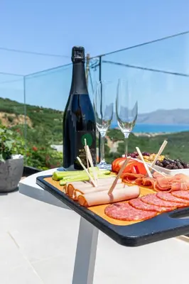 a table with a plate of food and wine glasses at Mansion Fabrica in Kalleryianá