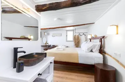 a bedroom with a large bed and a sink at Mansion Fabrica in Kalleryianá