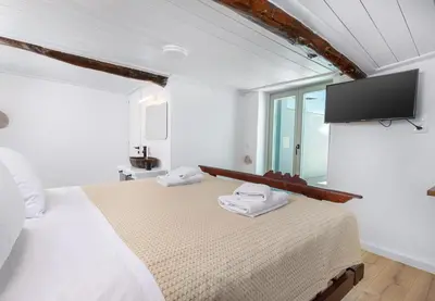 a bedroom with a bed with a flat screen tv on the wall at Mansion Fabrica in Kalleryianá