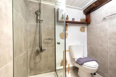 a bathroom with a toilet and a glass shower at Mansion Fabrica in Kalleryianá