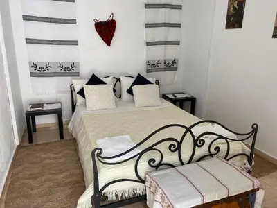 a bedroom with a black and white bed and a bench at Casa Elafonisi N1- 10min from the beach in Plokamianá