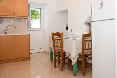 a kitchen with a table and chairs and a refrigerator at Casa Elafonisi N1- 10min from the beach in Plokamianá