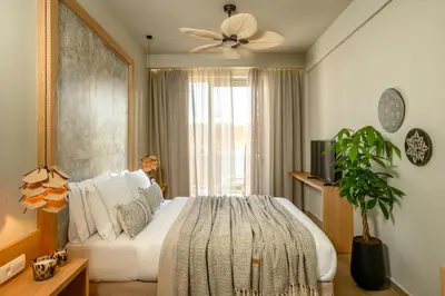 a bedroom with a large bed with a ceiling fan at Casbah Boutique Hotel in Palaiochóra