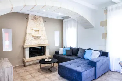 a living room with a couch and a fireplace at Sonio Villas - Que Bella Collection in Plataniás