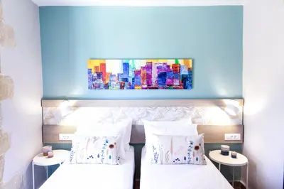 a bedroom with two beds and a painting on the wall at Sonio Villas - Que Bella Collection in Plataniás