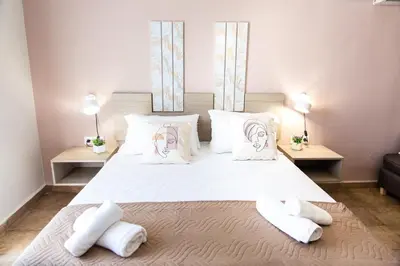 a bedroom with a large bed with white pillows at Sonio Villas - Que Bella Collection in Plataniás