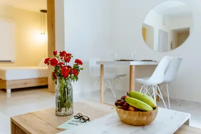 a table with a vase of flowers and a bowl of fruit at Emeli Suites in Chania Town