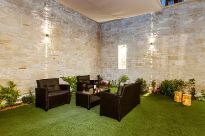 a room with chairs and a table and a brick wall at Emeli Suites in Chania Town