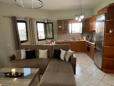 a living room with a couch and a kitchen at Eteá Urban Nest living In the Heart of Chania in Chania Town