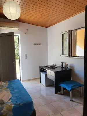 a room with a bed and a desk and a table at Chania Casa Portokali in Perivólia