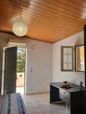 a room with a bed and a desk and a ceiling at Chania Casa Portokali in Perivólia