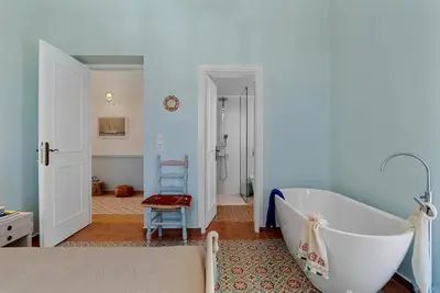 a bathroom with a white tub and a chair at Villa Remedio in Néon Khoríon