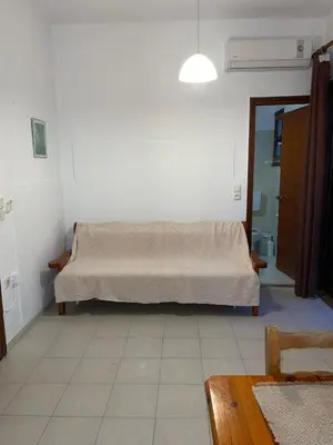a bedroom with a bed in the corner of a room at Livadia Studios in Ropanianá