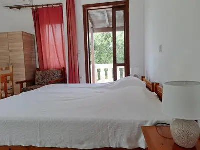 a bedroom with a large white bed and a window at Livadia Studios in Ropanianá