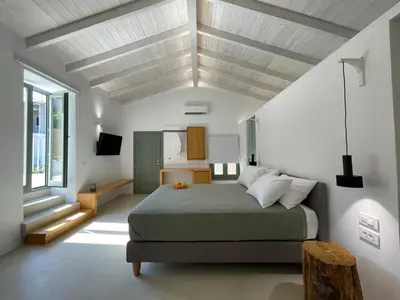 a bedroom with a large bed and a large window at Lithos Retreat (ΛΙTHOS Retreat) in Kolymvari