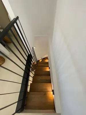 a staircase in a house with wooden floors and white walls at Lithos Retreat (ΛΙTHOS Retreat) in Kolymvari