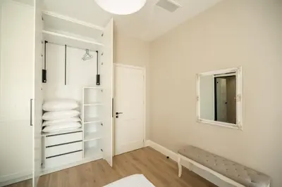 a white bathroom with a bench and a mirror at Amalthia Casa by 8essentially in Chania Town