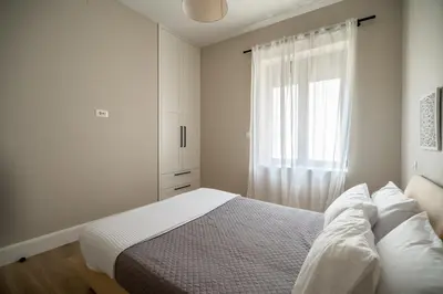a white bedroom with a bed and a window at Amalthia Casa by 8essentially in Chania Town
