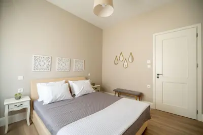 a white bedroom with a bed with white pillows at Amalthia Casa by 8essentially in Chania Town