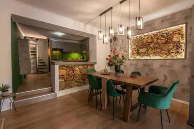 a dining room with a wooden table and green chairs at Casa Del Miele, private pool, BBQ, mountain view. in Alikianós
