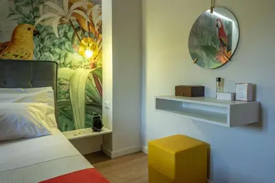 a bedroom with a bed with a bird painting on the wall at Casa Del Miele, private pool, BBQ, mountain view. in Alikianós