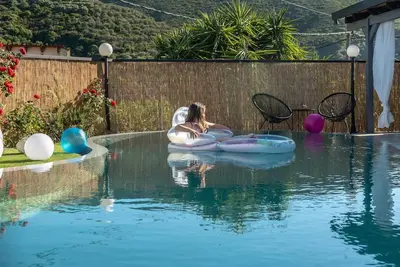 a woman is sitting on an inner tube in a pool at Casa Del Miele, private pool, BBQ, mountain view. in Alikianós