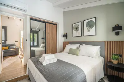a bedroom with a large bed and a living room at Antigone's Lux Home 10mins walk to beach, old town, city in Chania Town