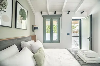 a bedroom with a white bed and a window at Antigone's Lux Home 10mins walk to beach, old town, city in Chania Town
