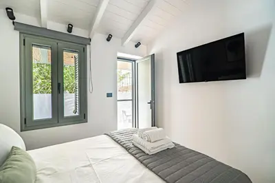 a bedroom with a bed and a flat screen tv at Antigone's Lux Home 10mins walk to beach, old town, city in Chania Town