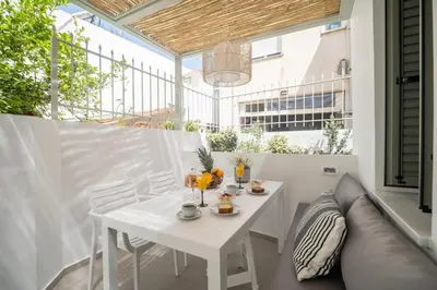 a white table and chairs on a balcony at Antigone's Lux Home 10mins walk to beach, old town, city in Chania Town