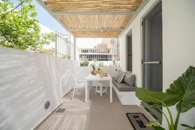 an outdoor balcony with a table and a chair at Antigone's Lux Home 10mins walk to beach, old town, city in Chania Town