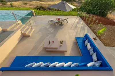 an overhead view of a patio with a blue couch and pillows at Villa Anastasia with private heated pool and privacy in Chania Town