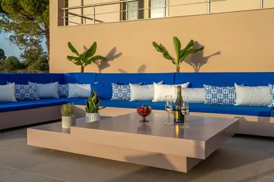 a blue couch and a table with a bottle of wine at Villa Anastasia with private heated pool and privacy in Chania Town