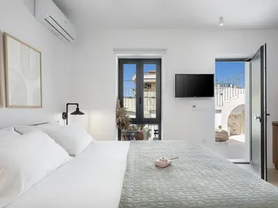 a bedroom with a white bed with a pink toy on it at Lithos Retreat 2(ΛΙTHOS Retreat) in Kolymvari