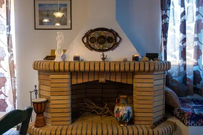 a living room with a brick fireplace with a vase at Villa Jokasta & Erato in Chania Town