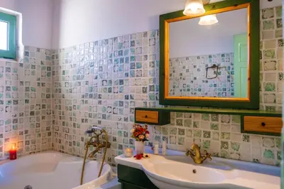 a bathroom with a tub and a sink and a mirror at Villa Jokasta & Erato in Chania Town