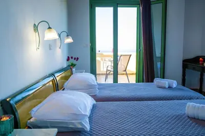 two beds in a room with a view of the ocean at Villa Jokasta & Erato in Chania Town