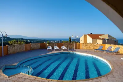 a swimming pool on a patio with chairs at Villa Jokasta & Erato in Chania Town