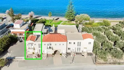 an aerial view of a house with the ocean in the background at Adelphes Beachfront Apartment with direct connection to the beach in Chania Town