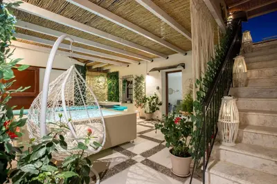 a patio with a swing and a swimming pool at Belle Epoque Halepa's House & Studio in Chania Town