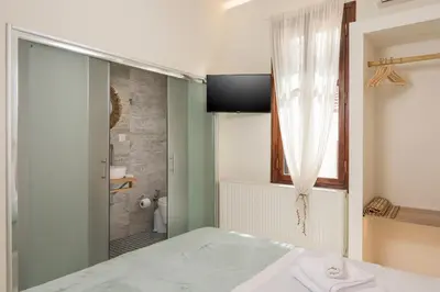a bathroom with a shower and a bed in a room at Belle Epoque Halepa's House in Chania Town