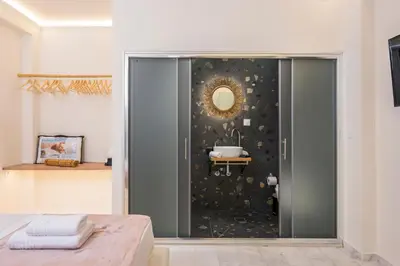 a bathroom with a glass shower with a sink at Belle Epoque Halepa's House in Chania Town