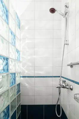 a bathroom with a shower with blue and white tiles at Origeo casa in Maleme