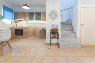 a kitchen with a staircase and a table and chairs at Origeo casa in Maleme
