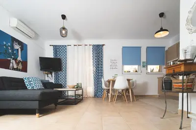 a living room with a couch and a table and chairs at Origeo casa in Maleme