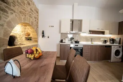 a kitchen with a table with a bowl of fruit on it at Villa Konstantinos in Azoyirás