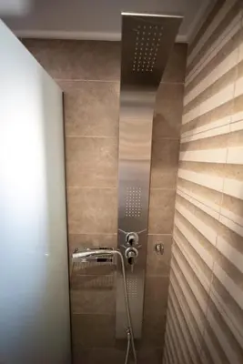 a bathroom with a shower with wooden walls at Villa Konstantinos in Azoyirás