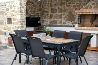 a kitchen with a table and chairs and a stove at Villa Konstantinos in Azoyirás