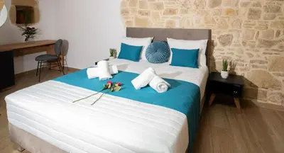 a bedroom with a large bed with blue and white pillows at Villa Konstantinos in Azoyirás