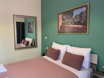 a bedroom with a large bed and two mirrors at Kissamos Nice Apartment2 in Kissamos